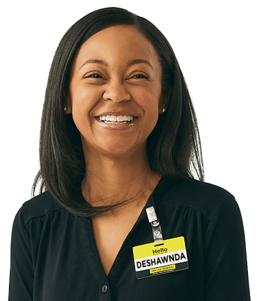 A smiling woman with straight dark hair wears a black top and a yellow name badge that says “Hello, DESHAWNDA, DIGITAL MANAGER” on her left side.